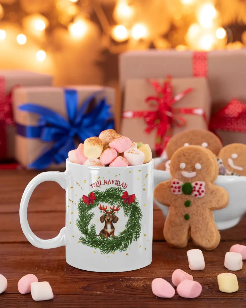 Rodeada de regalos, lazos de colores, galletas y nubes para celebrar la Navidad, se encuentra la taza más simpática de todas, la taza "Salchicha" con el diseño de un cachorro de Salchicha con unos cuernos de reno y enmarcado en una corona de guirnalda navideña.